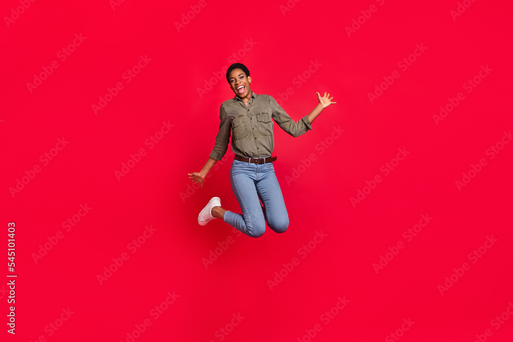Full length body size view of attractive cheerful girl jumping good mood isolated over vivid red color background