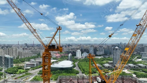 Cranes and construction site in the city. Drone aerial view. House development project and building in construction in Shanghai China.  Industry, business, house development concept b-roll footage.