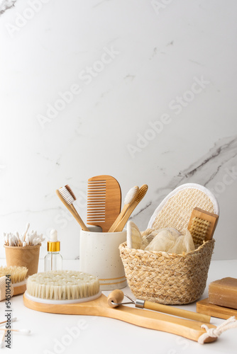 Wooden toothbrushes with natural bristles in a ceramic glass, face and skin care products, bath accessories, spa and beauty concept