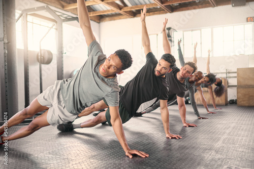 Fitness, exercise and training with a sports group stretching together in gym class for health or wellness. Workout, diversity and coach with a team warmup in a sport facility for performance