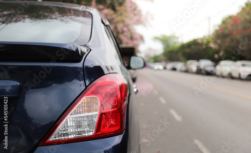 Closeup of rear, back side of black car parking beside the street. © Amphon