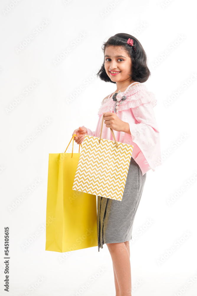Happy Indian little girl holding shopping bags on white background. Happy Indian little girl holding shopping bags on white background.