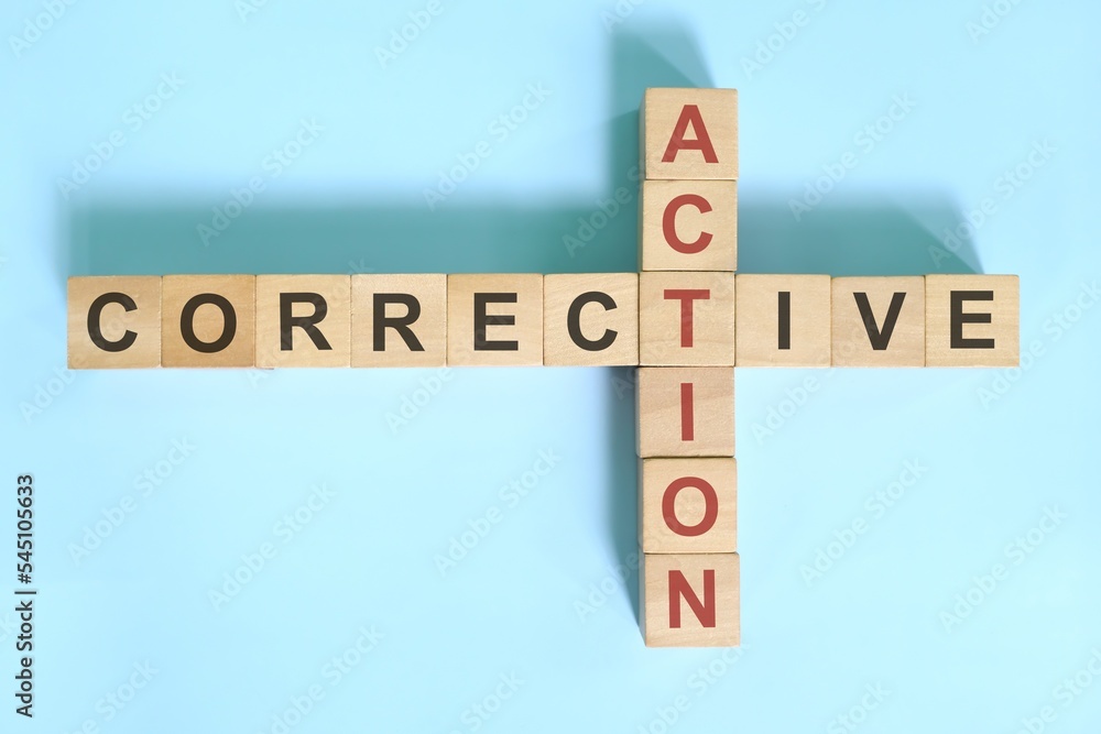 Corrective action business concept. Wooden blocks crossword puzzle flat lay.