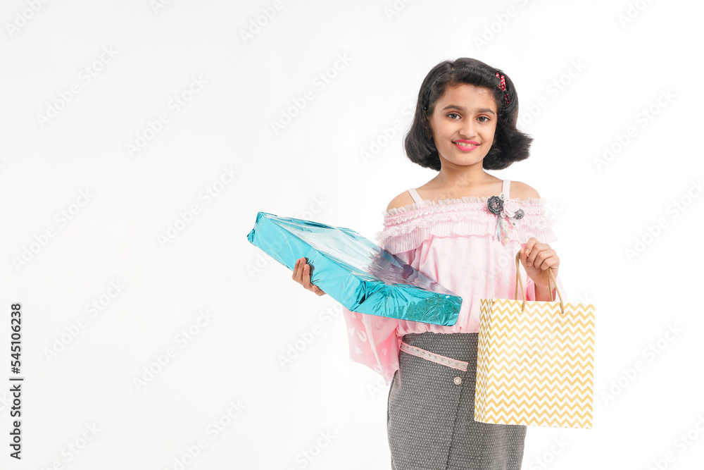 Cute indian little girl Child with gifts boxes and shopping bag standing on white background. Cute indian little girl Child with gifts boxes and shopping bag standing on white background.