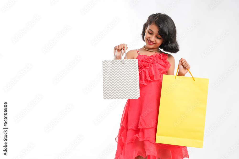Happy Indian little girl holding shopping bags on white background. Happy Indian little girl holding shopping bags on white background.