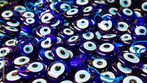 Lot of traditional Turkish amulet Evil Eye or blue eye (Nazar boncugu). Souvenir of Turkey and traditional turkish amulet. Close up, selected focus, shallow depth. Travel souvenir or gift concept photo