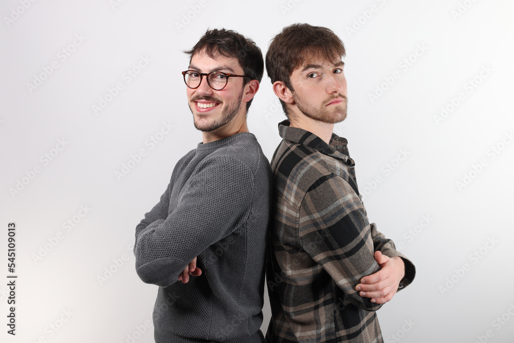 deux jeunes amis sont dos à dos, souriant et les bras croisés. Détouré, sur fond blanc deux jeunes amis sont dos à dos, souriant et les bras croisés. Détouré, sur fond blanc