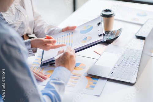 Group of business people meeting together Pointing to the graph assess business profits.