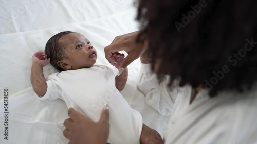 Closeup portrait of beautiful young African American mother day girl kiss healthy newborn baby sleep in bed flat lay copy space. Healthcare medical love black woman lifestyle mother's day, top view