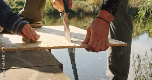 happy father and son building a tree house in the garden