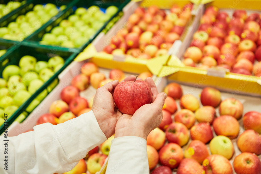 Hände eines Kunden halten einen Apfel auf dem Markt Hände eines Kunden halten einen Apfel auf dem Markt