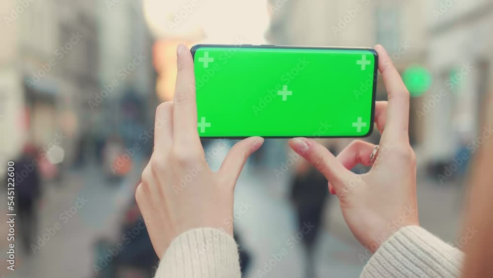 Young woman hands hold smart phone with horizontal green screen outdoors internet mobile smartphone technology city communication device use lifestyle slow motion Young woman hands hold smart phone with horizontal green screen outdoors internet mobile smartphone technology city communication device use lifestyle slow motion