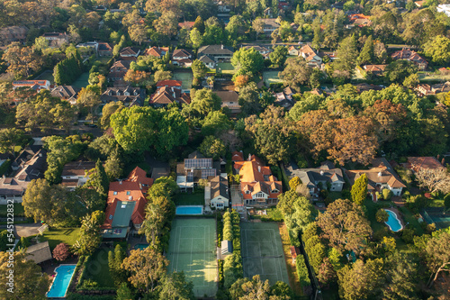 Aerial view of upmarket houses with private gardens, pools and tennis courts on Sydney's leafy North Shore.