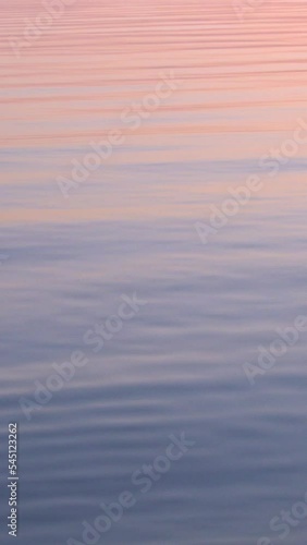 Majestic colorful sunset reflected in calm water surface