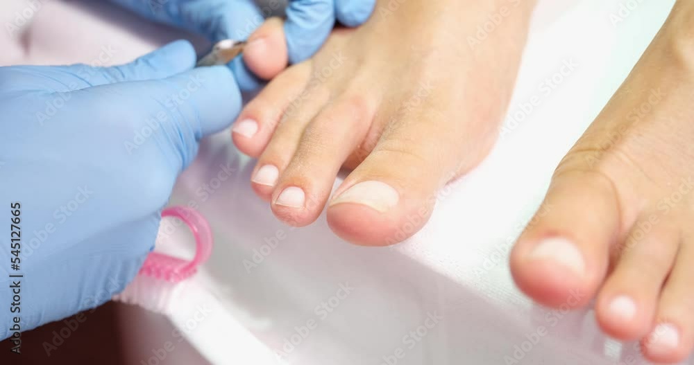 Pedicure salon employee uses nail clippers trimming toenails Pedicure salon employee uses nail clippers trimming toenails
