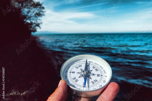 The right compass is always needed for travelers, adequate course. Hiking on the shore of Lake Baikal in Siberia photo