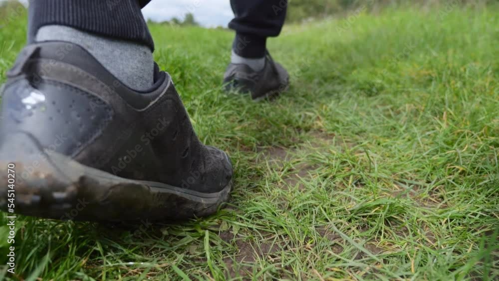 Close up of hiking boots walking in the grass, slow motion. Close up of hiking boots walking in the grass, slow motion.