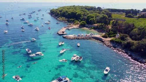 Flying around the port of Saint Honorat island part of the Iles de Lérins, next to Cannes in south of France. Clear watter of the mediterranean sea, little boats, wineyards and monastery on the island photo