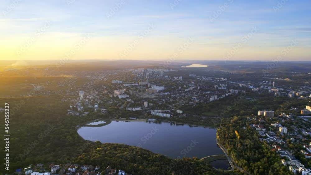 Aerial drone view of Chisinau at sunset, Moldova. Valea Morilor Park with lush greenery and lake. Panoramic view of multiple buildings Aerial drone view of Chisinau at sunset, Moldova. Valea Morilor Park with lush greenery and lake. Panoramic view of multiple buildings