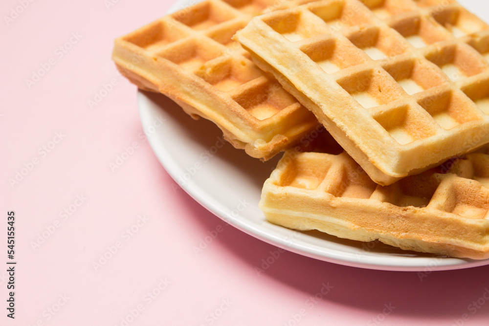 Homemade waffles on a pink background. Tasty breakfast Homemade waffles on a pink background. Tasty breakfast
