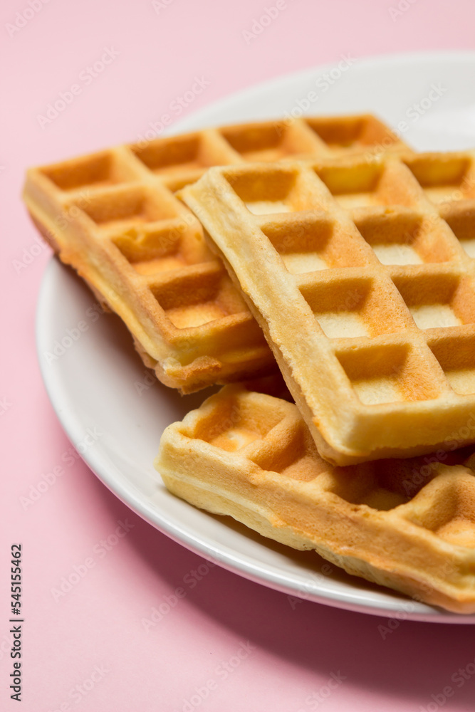 Homemade waffles on a pink background. Tasty breakfast Homemade waffles on a pink background. Tasty breakfast