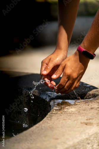 hands refreshing themselves with water in a fountain