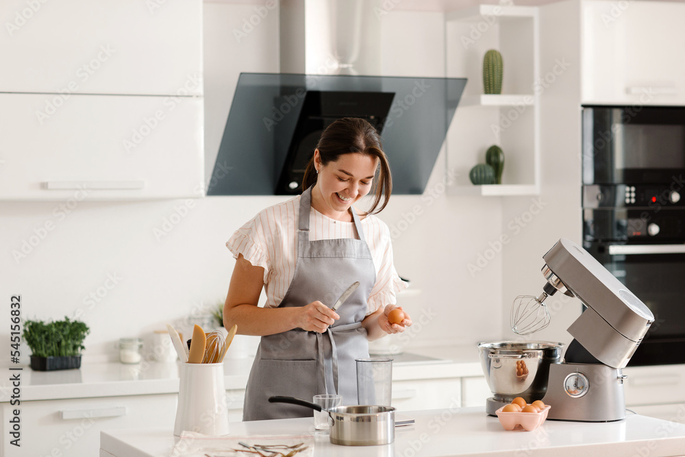 woman confectioner prepares a cake in the kitchen at home. Home baking for the whole family. High quality photo woman confectioner prepares a cake in the kitchen at home. Home baking for the whole family. High quality photo