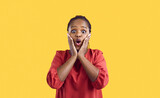 Wow. Amazed surprised african american woman looking at you with open mouth and big eyes on yellow background. Close up portrait of woman unable to believe what she hears or sees. Banner.
