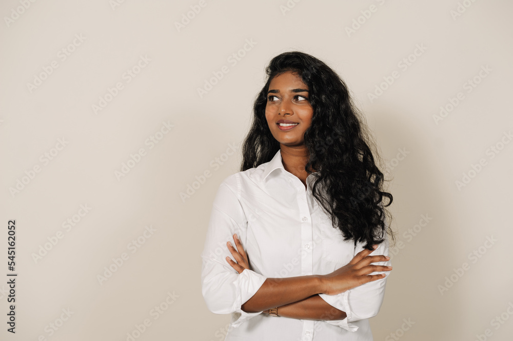 Young indian woman smiling at camera and standing with arms folded Young indian woman smiling at camera and standing with arms folded