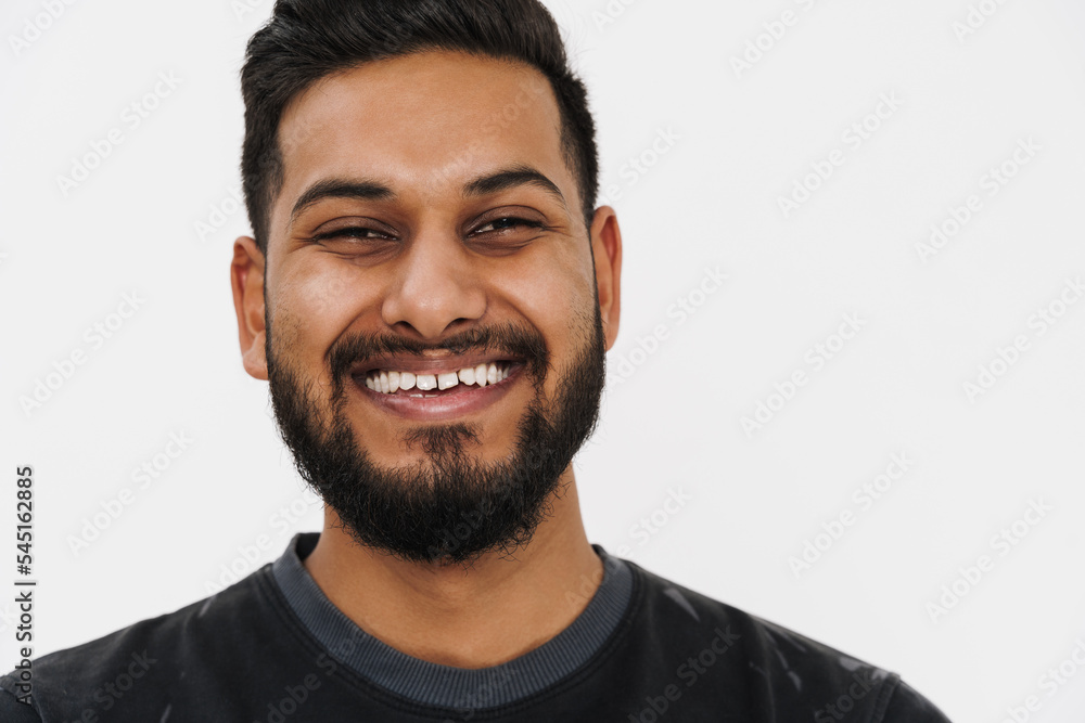 Young indian man with beard smiling and looking at camera Young indian man with beard smiling and looking at camera
