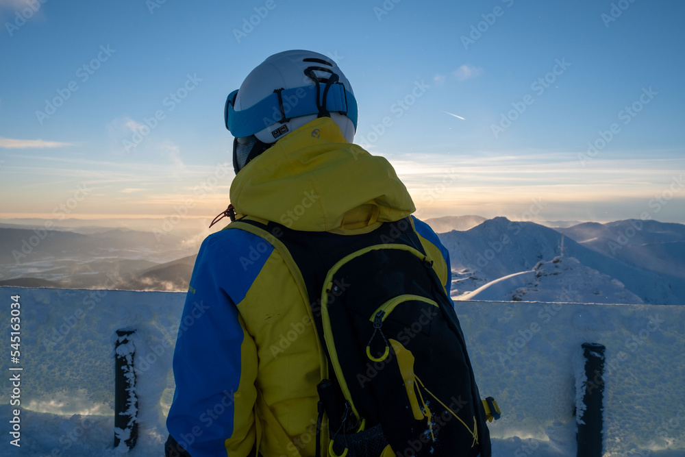 woman skier looking at sunset above slovakia mountains