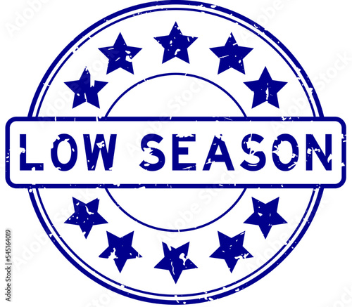 Grunge blue low season word with star icon round rubber seal stamp on white background
