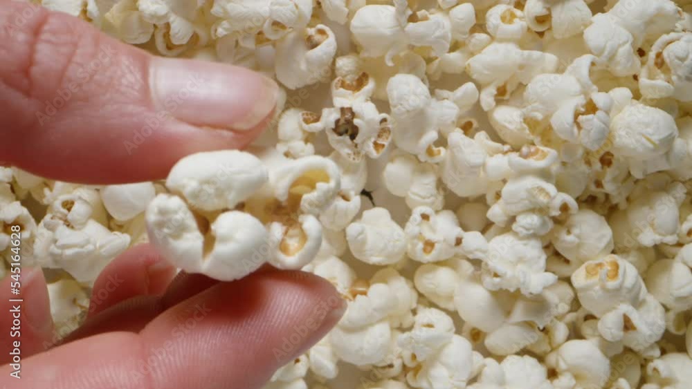 Top view of the popcorn, I take one and bring it close to the camera, close-up. Top view of the popcorn, I take one and bring it close to the camera, close-up.