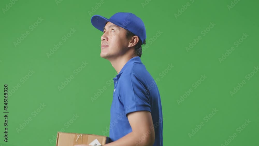 Close Up Side View Of Smiling Asian Male Courier In Blue Uniform Walking And Looking Around While Delivering A Carton On Green Screen Background In The Studio
Close Up Side View Of Smiling Asian Male Courier In Blue Uniform Walking And Looking Around While Delivering A Carton On Green Screen Background In The Studio