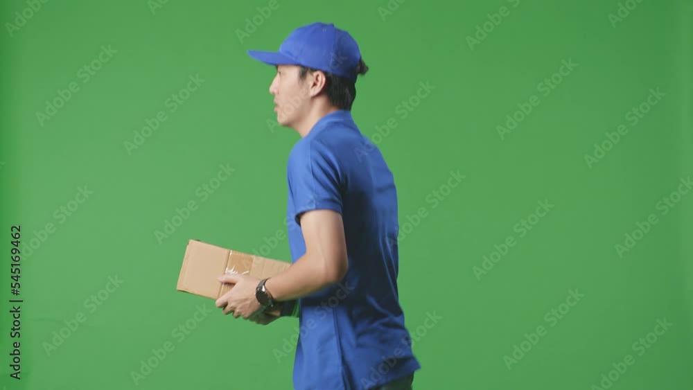 Side View Of Asian Male Courier In Blue Uniform Checking Watch And Running While Delivering A Carton On Green Screen Background In The Studio
Side View Of Asian Male Courier In Blue Uniform Checking Watch And Running While Delivering A Carton On Green Screen Background In The Studio
