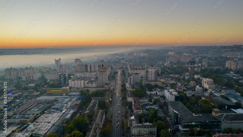 Aerial drone timelapse view of Chisinau at sunrise, Moldova. View of city centre covered with fog, multiple buildings, moving cars Aerial drone timelapse view of Chisinau at sunrise, Moldova. View of city centre covered with fog, multiple buildings, moving cars