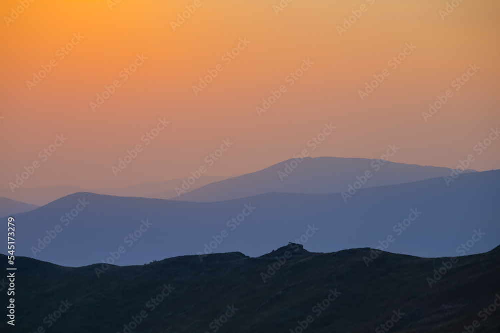 mountain chain silhouette in blue mist at the sunset, early morning mountain travel scene mountain chain silhouette in blue mist at the sunset, early morning mountain travel scene