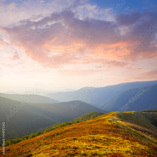 mountain chain silhouette in blue mist at the sunset, early morning mountain travel scene