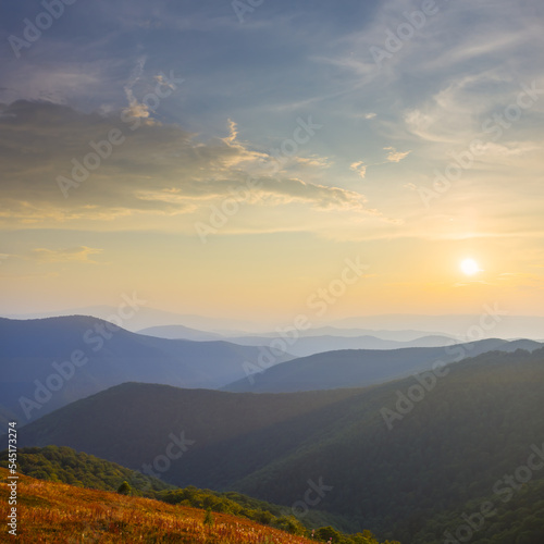mountain chain silhouette in blue mist at the sunset, early morning mountain travel scene