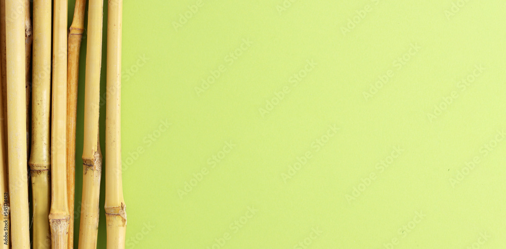 Eco bamboo on green background. Concept, natural material organic cutlery, zero waste, eco-friendly, banner, copyspace Eco bamboo on green background. Concept, natural material organic cutlery, zero waste, eco-friendly, banner, copyspace