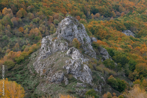 Beautiful view of a rock formation among autumn trees that surround it in Valle de Anciles, León, Spain photo