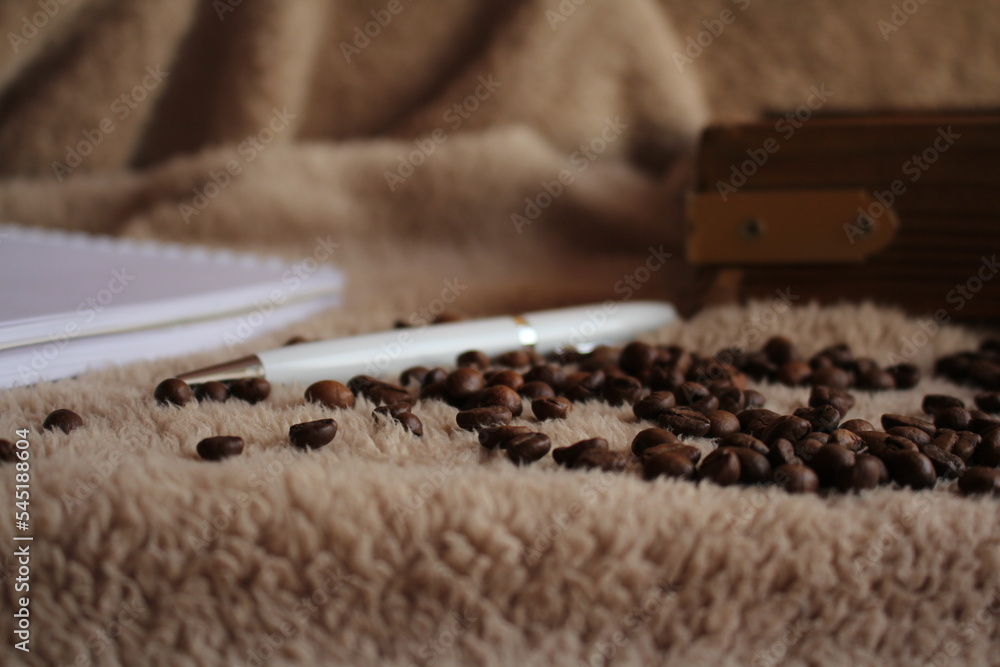The pen is on the table. Coffee, a wooden tray of cinnamon, and a candle are strewn nearby. Morning. Postcard for the inscription of wishes. The pen is on the table. Coffee, a wooden tray of cinnamon, and a candle are strewn nearby. Morning. Postcard for the inscription of wishes.