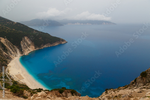 Top view at Myrtos Beach from road during bad weather conditions, thunderstorm and rain, with low dark clouds over sea. Cephalonia, Greece