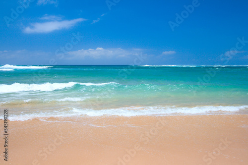 Peaceful beach scene with ocean and blue sky