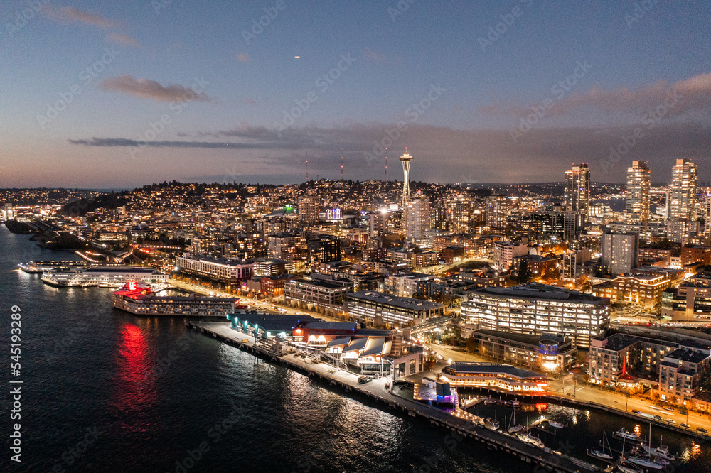 Seattle, Washington, USA - November 2022, night aerial view of illuminated Seattle Downtown and the Waterfront pier area with famous Space Needle Tower - aerial night view  	