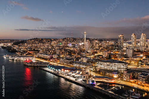 Seattle, Washington, USA - November 2022, night aerial view of illuminated Seattle Downtown and the Waterfront pier area with famous Space Needle Tower - aerial night view 