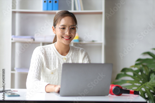 Attractive young woman working with laptop at home office. © Wasan