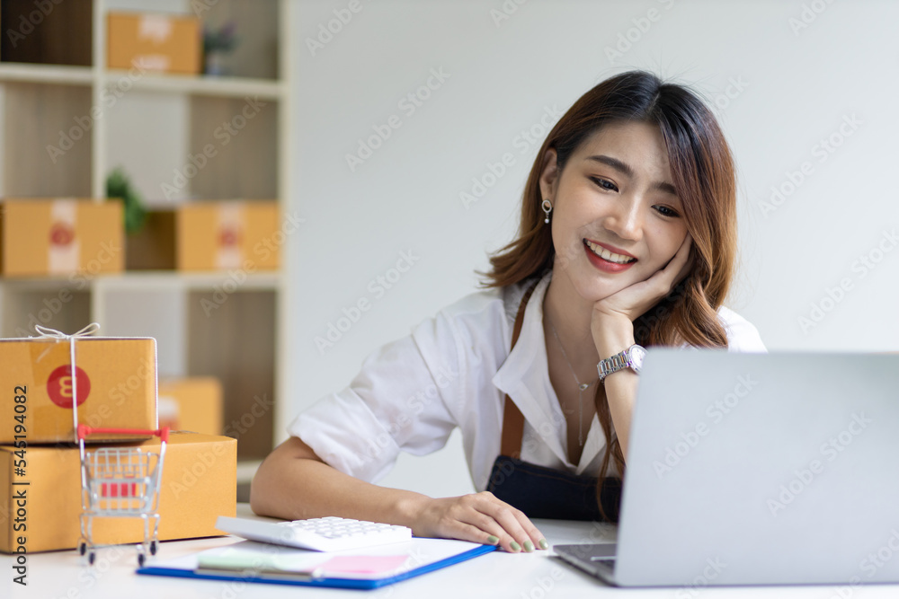 Portrait of Asian young woman SME working with a box at home the workplace.start-up small business owner, small business entrepreneur SME or freelance business online and delivery concept. Portrait of Asian young woman SME working with a box at home the workplace.start-up small business owner, small business entrepreneur SME or freelance business online and delivery concept.