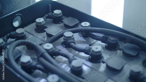 Modern new gray color battery blocks are connected by powerful jumpers into a single high-power battery. Shot in motion. Closeup