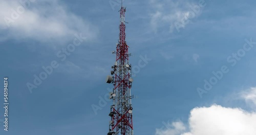 Transmission tower against fast moving clouds and blue sky
